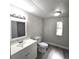 Bright bathroom featuring a vanity with sink, toilet, and framed mirror above the sink at 2434 Trenton E Rd, Lakeland, FL 33815