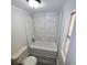 Cozy bathroom featuring modern white tiling in the shower, updated fixtures, and wood-look flooring at 2434 Trenton E Rd, Lakeland, FL 33815