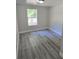 Bedroom featuring a window and new gray vinyl plank flooring at 2434 Trenton E Rd, Lakeland, FL 33815
