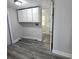 Bright laundry room with modern flooring, convenient white cabinets, and adjacent bathroom access at 2434 Trenton E Rd, Lakeland, FL 33815