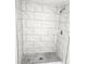 Upgraded tiled shower featuring gray and white tiling and a shower head at 2434 Trenton E Rd, Lakeland, FL 33815