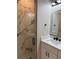 Bathroom featuring a glass door shower with marble tile, modern sink and a backlit mirror at 209 W 6Th St, Lakeland, FL 33805