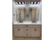 Modern bathroom featuring a double sink vanity with a white countertop, black hardware, and two backlit mirrors at 209 W 6Th St, Lakeland, FL 33805