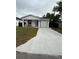 Newly renovated single-story home featuring a pristine white exterior, modern black trim, and an inviting one-car garage at 209 W 6Th St, Lakeland, FL 33805