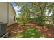 Private backyard featuring a mulched garden bed with green grass and large mature tree at 2121 Escobar Ave, Lady Lake, FL 32159