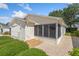 A bright exterior view shows the house's enclosed lanai and attached garage at 2121 Escobar Ave, Lady Lake, FL 32159