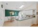 Bright eat-in kitchen with white cabinetry, a skylight, and stylish green accent wall at 2121 Escobar Ave, Lady Lake, FL 32159