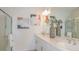 Bright bathroom with double sinks, a large mirror, neutral paint and a glass-enclosed shower at 2415 Slippery Rock St, Auburndale, FL 33823