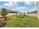 Spacious backyard with lush lawn, garden beds, and partial fence at 392 Summer Squall Rd, Davenport, FL 33837
