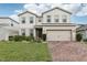 Charming two-story home with a well-manicured lawn, paved driveway, and attached two-car garage at 392 Summer Squall Rd, Davenport, FL 33837