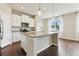 Contemporary kitchen with white cabinetry, granite countertops, stainless appliances, and a functional island with bar seating at 392 Summer Squall Rd, Davenport, FL 33837