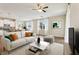 Bright and airy living room featuring a comfortable couch, modern decor, and a seamless flow to the kitchen at 392 Summer Squall Rd, Davenport, FL 33837