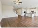 Open living space with dark hardwood floors flowing into a kitchen with white cabinets and stainless steel appliances at 392 Summer Squall Rd, Davenport, FL 33837