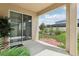 Covered patio with sliding glass door offers a view of landscaped backyard at 392 Summer Squall Rd, Davenport, FL 33837