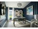Stylish home office with navy walls, modern desk, white shelves, large window, and a bright rug at 6230 Sw 95Th Pl, Ocala, FL 34476