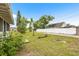 Expansive backyard featuring mature trees, green grass, and a secure white fence creating a private outdoor space at 1002 Ne 1St St, Mulberry, FL 33860
