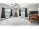 Bright bedroom with plush carpet, dual windows, ceiling fan, and desk perfect for a home office at 1002 Ne 1St St, Mulberry, FL 33860