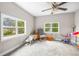Sun-filled bedroom with large windows, ceiling fan, and plush carpet offering a versatile living space at 1002 Ne 1St St, Mulberry, FL 33860