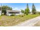Exterior view of the property, featuring a screened patio, and large lawn at 1002 Ne 1St St, Mulberry, FL 33860