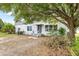 Charming single-story home featuring a tidy front yard, mature tree, and freshly painted exterior at 1002 Ne 1St St, Mulberry, FL 33860
