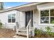 Charming home entrance features a covered porch, gray siding, and a well-maintained yard at 1002 Ne 1St St, Mulberry, FL 33860