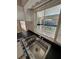 Close up on a stainless steel kitchen sink under a window looking out to the backyard at 5532 Stull Ave, Orlando, FL 32810