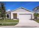 Charming single-Gathering home featuring a manicured lawn, two-car garage, and classic architectural details at 1038 Foreshore Ln, Haines City, FL 33844