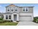 Charming two-story home with light-gray siding, a two-car garage, and a well-manicured front yard at 1205 Tidal St, Haines City, FL 33844