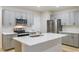Modern kitchen with grey cabinets, stainless steel appliances, and an island with quartz countertop at 3775 King Hill Dr, Haines City, FL 33844