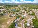 This aerial showcases a charming neighborhood with mature trees, a serene lake, and a view of the distant cityscape at 728 Waterbridge Dr, Winter Haven, FL 33880