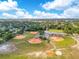 This aerial view showcases a well-maintained baseball field complex surrounded by greenery and clear blue skies at 728 Waterbridge Dr, Winter Haven, FL 33880