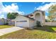 Charming two-story home featuring an attached two-car garage and well-manicured lawn under a bright blue sky at 728 Waterbridge Dr, Winter Haven, FL 33880