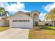 Charming two-story home featuring an attached two-car garage and well-manicured lawn under a bright blue sky at 728 Waterbridge Dr, Winter Haven, FL 33880