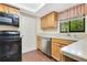 Well-lit kitchen featuring stainless steel appliances, wooden cabinetry, and a window at 728 Waterbridge Dr, Winter Haven, FL 33880