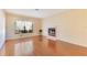 Bright living room with hardwood floors, a cozy fireplace, and a large window allowing ample natural light at 728 Waterbridge Dr, Winter Haven, FL 33880