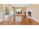 Spacious living room featuring a fireplace, hardwood floors, a large window, and access to the kitchen at 728 Waterbridge Dr, Winter Haven, FL 33880