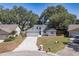 Inviting home with a two-car garage, well-manicured lawn, and mature trees enhancing curb appeal at 748 Sagewood Dr, Lakeland, FL 33813