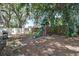 Backyard with a playset, grill, mature trees, and a wooden fence at 748 Sagewood Dr, Lakeland, FL 33813