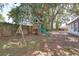 Spacious backyard featuring a wooden playset with swings and a slide at 748 Sagewood Dr, Lakeland, FL 33813