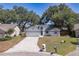 Aerial view of well-maintained home with a blue and white trim and mature trees at 748 Sagewood Dr, Lakeland, FL 33813