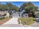 Inviting home with a two-car garage, well-manicured lawn, and mature trees enhancing curb appeal at 748 Sagewood Dr, Lakeland, FL 33813