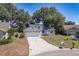 Inviting home with a two-car garage, well-manicured lawn, and mature trees enhancing curb appeal at 748 Sagewood Dr, Lakeland, FL 33813