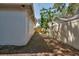 A view of the side yard with a white exterior wall and a wooden fence at 748 Sagewood Dr, Lakeland, FL 33813