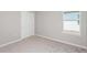 Bright, carpeted bedroom with a closet and a window offering natural light at 9060 Wildlight Trl, Wildwood, FL 34785