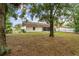 A spacious backyard featuring mature trees and a screened in porch for relaxing outdoors at 332 Sand Pine Trl, Winter Haven, FL 33880