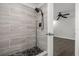 Bathroom with tiled shower, black shower head, and black honeycomb tile floor at 332 Sand Pine Trl, Winter Haven, FL 33880