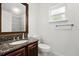 Bathroom featuring granite countertop, cherry wood cabinets, and a toilet at 332 Sand Pine Trl, Winter Haven, FL 33880
