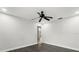 A bright, spacious bedroom featuring modern dark floors, white walls, and a contemporary ceiling fan at 332 Sand Pine Trl, Winter Haven, FL 33880