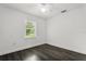 A bright, empty bedroom features a ceiling fan, a window, and hardwood floors at 332 Sand Pine Trl, Winter Haven, FL 33880