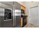 Kitchen showcasing stainless steel refrigerator and black appliances, next to a pantry door at 332 Sand Pine Trl, Winter Haven, FL 33880